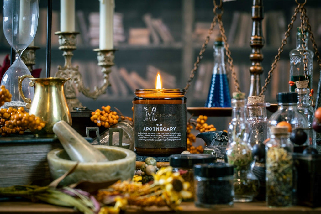 Apothecary pumpkin and patchouli coconut wax candle by Mythologie Candles beside a mortar and pestle and glass beakers (image 3)