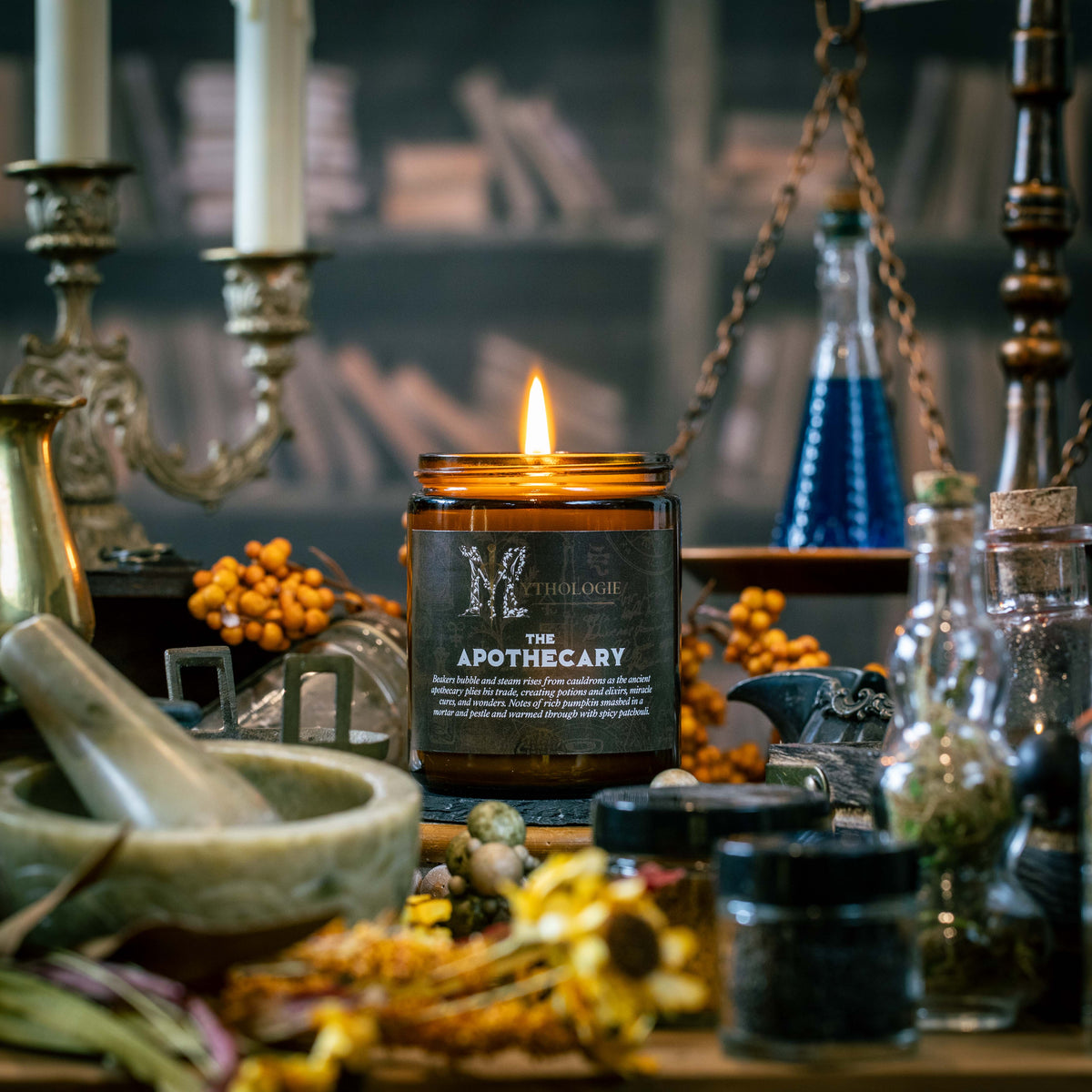 Apothecary pumpkin and patchouli coconut wax candle by Mythologie Candles beside a mortar and pestle and glass beakers